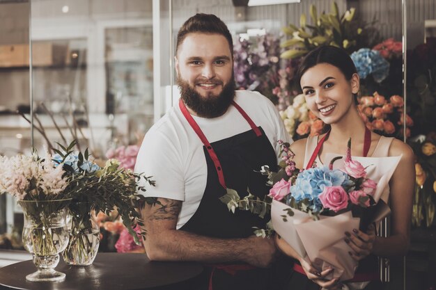Retrato de sonriente floristas hombre y mujer