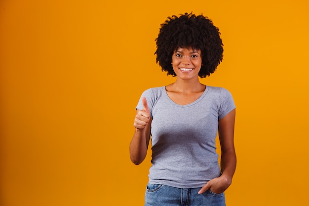 Retrato de sonriente hermosa joven afro pulgar hacia arriba. Chica brasileña.