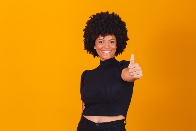 Retrato de sonriente hermosa joven afro pulgar hacia arriba. Chica brasileña.