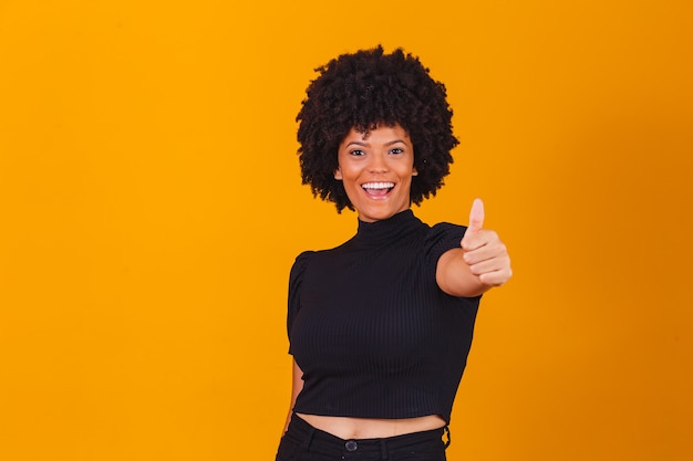 Retrato de sonriente hermosa joven afro pulgar hacia arriba. Chica brasileña.