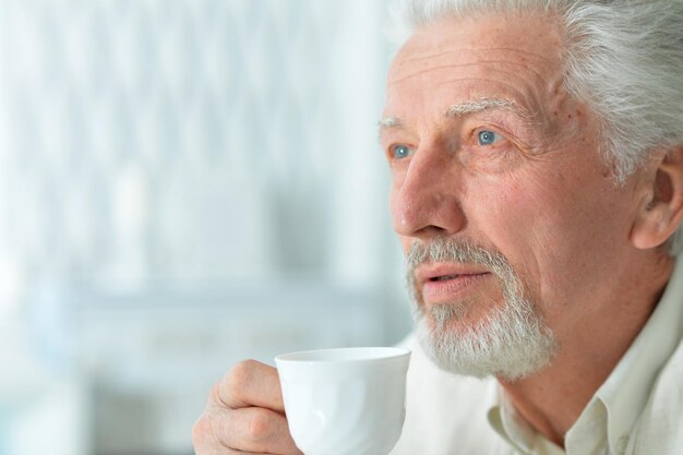 retrato, de, sonriente, hombre mayor, bebida, café