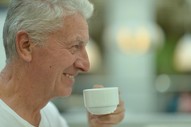 retrato, de, sonriente, hombre mayor, bebida, café