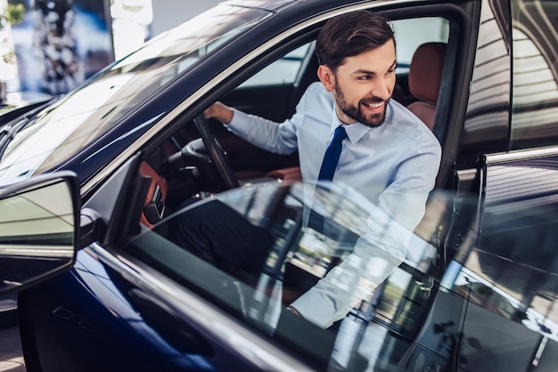 retrato, de, sonriente, hombre de negocios, el mirar lejos, mientras, sentado, en, coche