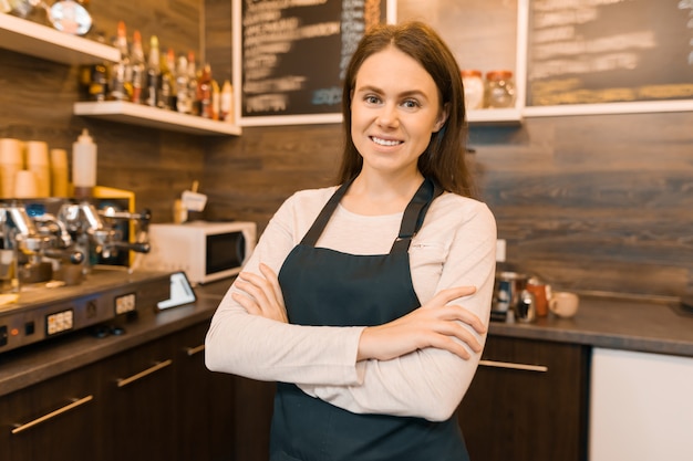 Retrato de sonriente joven dueño de cafetería femenina