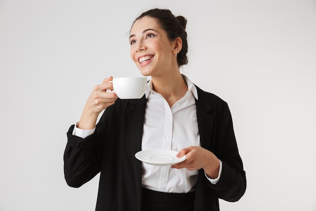 Retrato de una sonriente joven empresaria bebiendo té
