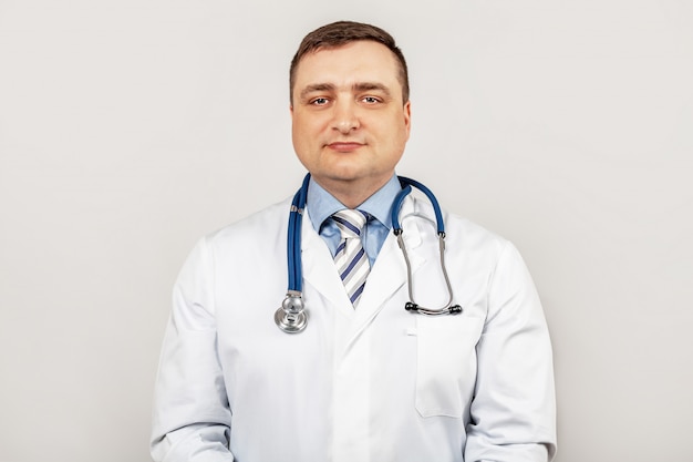 Retrato de sonriente joven médico masculino con un estetoscopio alrededor del cuello