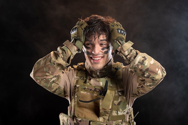 Retrato de sonriente joven soldado en uniforme de camuflaje