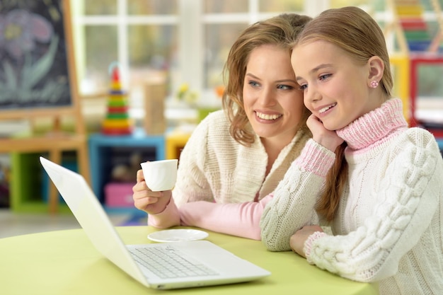 Retrato, de, sonriente, madre e hija, con, computador portatil