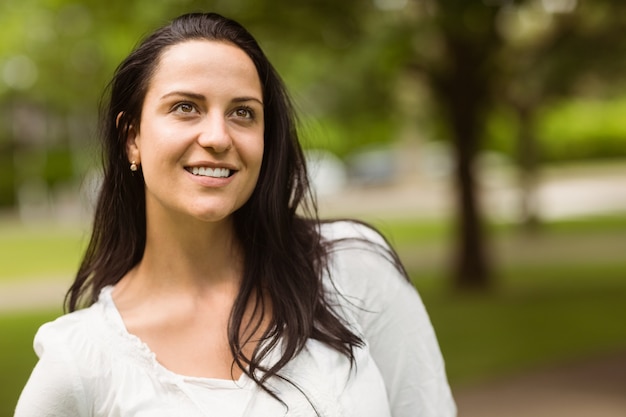 Foto retrato de una sonriente morena de pie