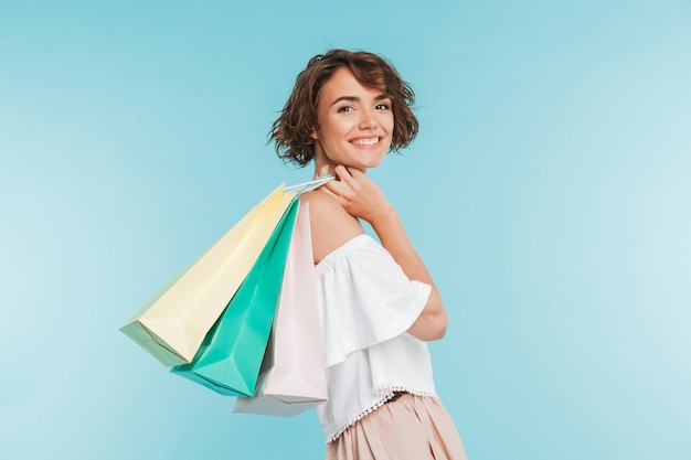 Retrato, de, un, sonriente, mujer joven, tenencia, bolsas de compras