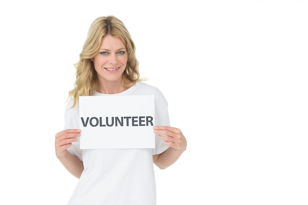 Retrato de una sonriente mujer joven voluntario celebración cartel