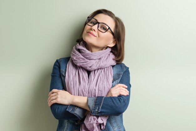 Retrato de sonriente mujer de mediana edad confía en gafas