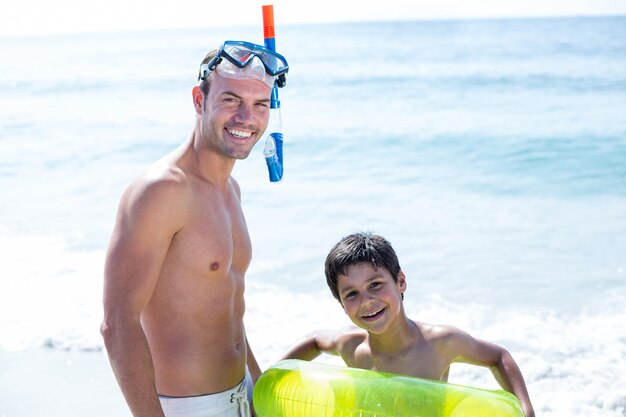 Retrato de sonriente padre e hijo en la playa