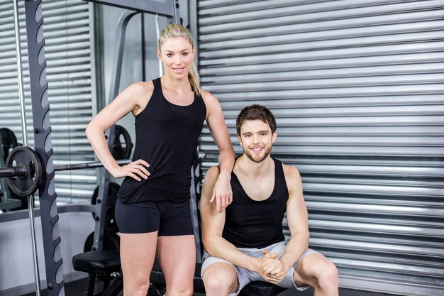 Retrato de la sonriente pareja en forma en el gimnasio crossfit