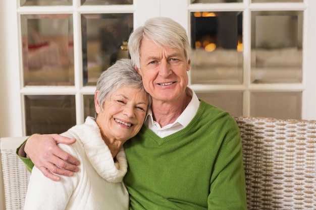 Retrato de sonriente pareja madura en la mesa