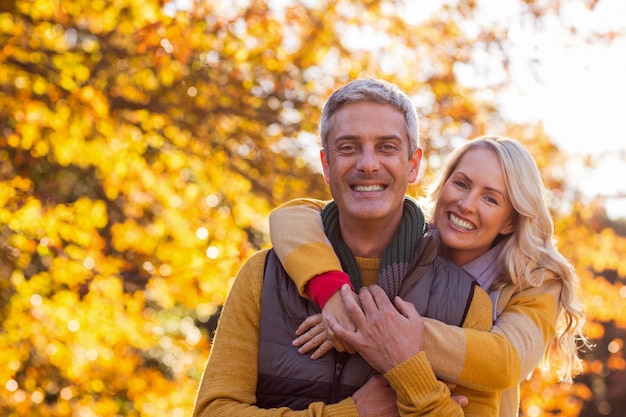 Retrato de la sonriente pareja de pie en el parque