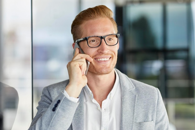 retrato, de, sonriente, pelirrojo, hombre de negocios, en, teléfono celular