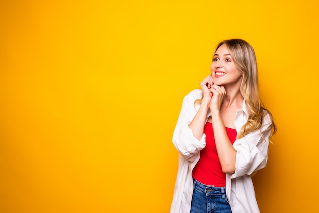 Retrato, de, un, sonriente, rubio, mujer joven, posición, aislado, encima, pared amarilla