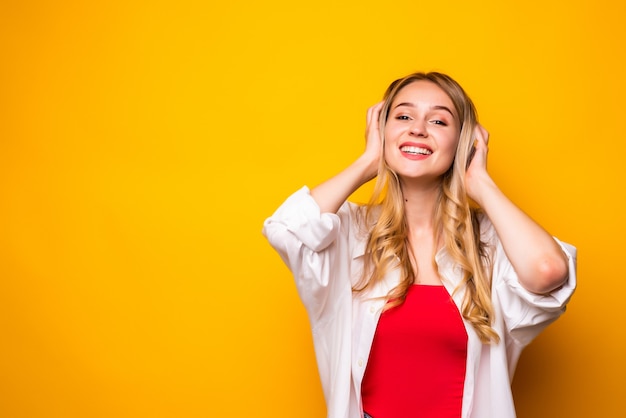 Retrato, de, un, sonriente, rubio, mujer joven, posición, encima, pared amarilla