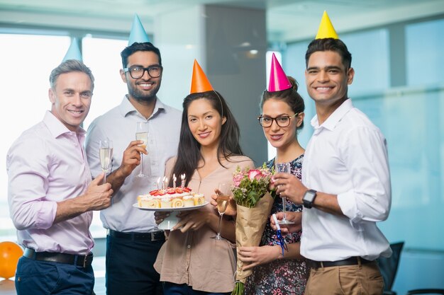 Foto retrato de sonrientes colegas celebrando un cumpleaños