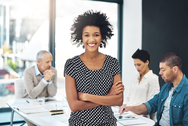 Retrato sonrisa y confianza mujer de negocios en la oficina reunión de coworking o líder de equipo en una startup creativa rostro feliz profesional y empresario con los brazos cruzados diseñador o empleado orgulloso