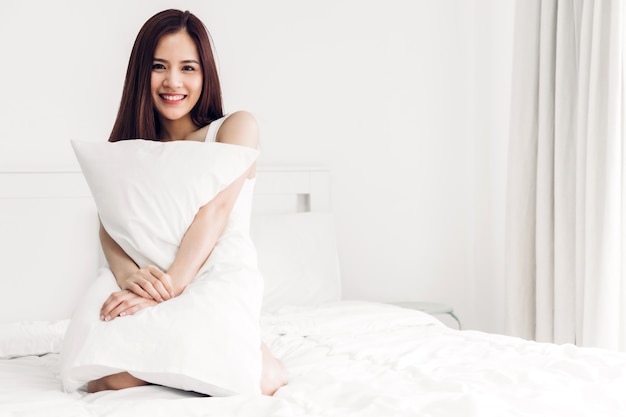 Retrato de sonrisa feliz asia mujer disfrutar y relajarse en la cama en el dormitorio en casa belleza asiática.