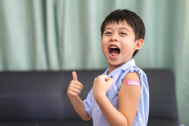 Retrato de sonrisa feliz vacunados niños pequeños asiáticos niños de 5 a 11 años posando mostrar el brazo con yeso médico después de la vacuna inyectable Protección Covid19 vacunación contra el coronavirus niño