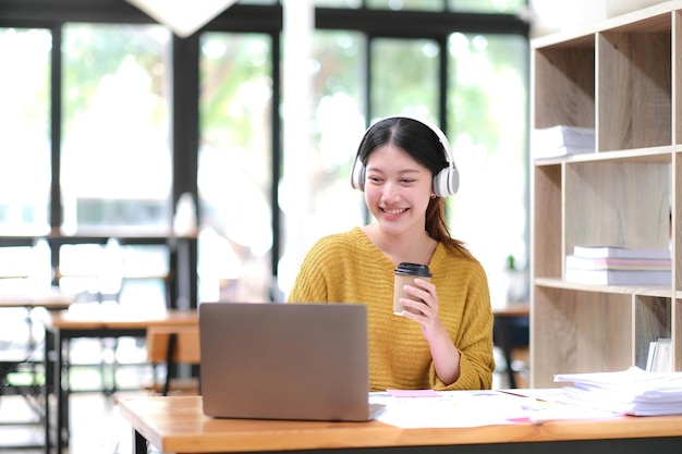 Retrato de una sonrisa hermosa mujer de negocios asiática que trabaja en una oficina con una computadora de escritorio Pequeña empresa con personas empleadas freelance en línea startup marketing diseñador de telemarketing exitoso
