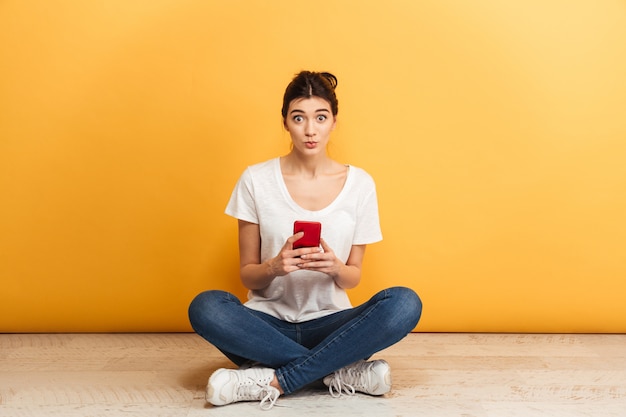 Retrato, de, un, sorprendido, mujer joven, tenencia, teléfono móvil