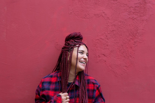 Retrato sorridente jovem com dreadlocks vermelhos vestindo uma camisa xadrez vermelha