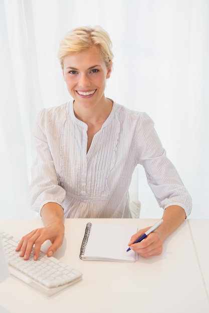 Retrato, sorrindo, loiro, mulher, usando computador