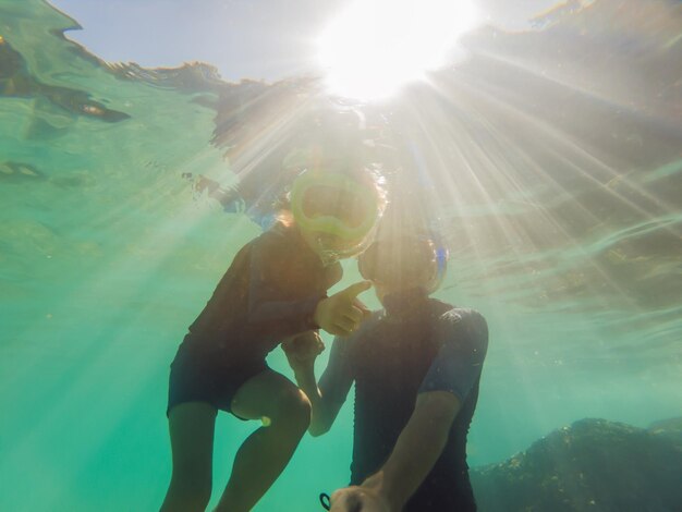 Retrato submarino de padre e hijo buceando juntos