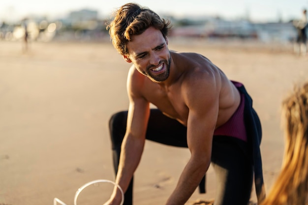 Retrato de un surfista preparándose para surfear mientras está de pie en una playa