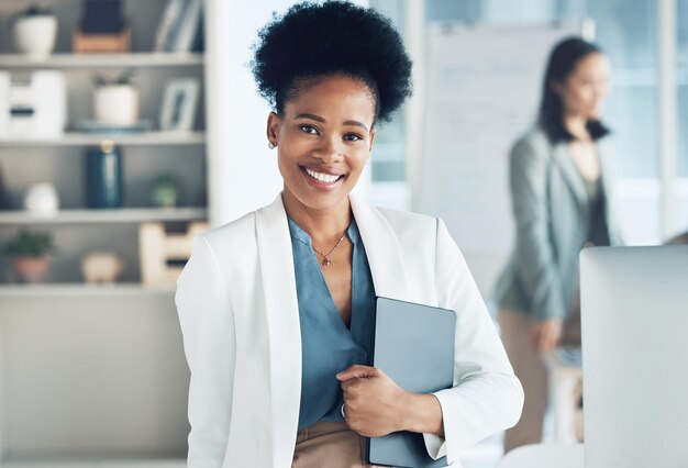 Retrato de tableta digital y mujer de negocios en la oficina con confianza mientras trabaja en un proyecto Sonrisa feliz y líder africana profesional de pie con un dispositivo móvil en el lugar de trabajo