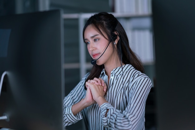 Retrato tailandês de empresário usando fone de ouvido trabalhando, agente de mulher jovem operador amigável em um call center.