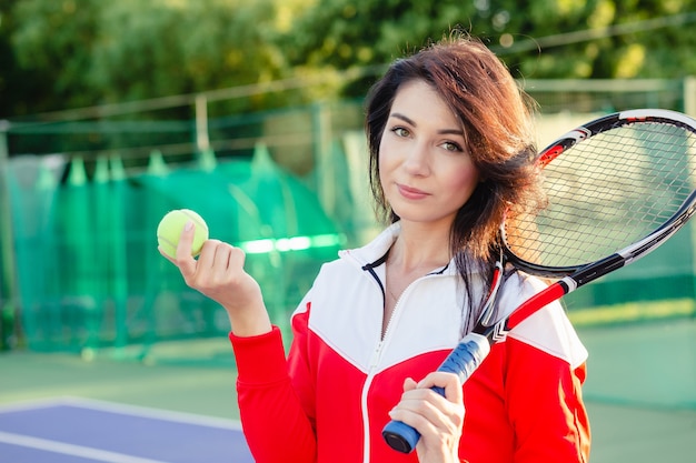 Retrato de tenista hermosa chica guapa con una raqueta en la cancha.