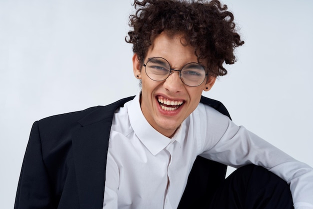 Retrato de un tipo de cabello rizado con una camisa, una chaqueta y gafas Foto de alta calidad