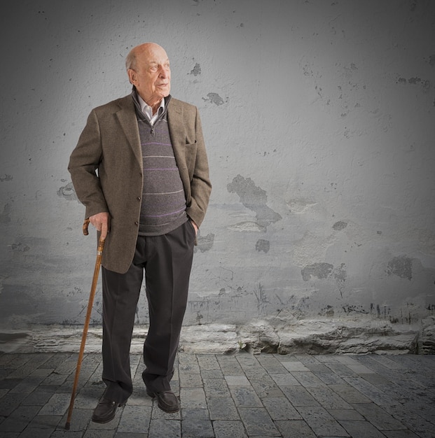 Foto retrato en toda su longitud de un hombre de pie contra la pared