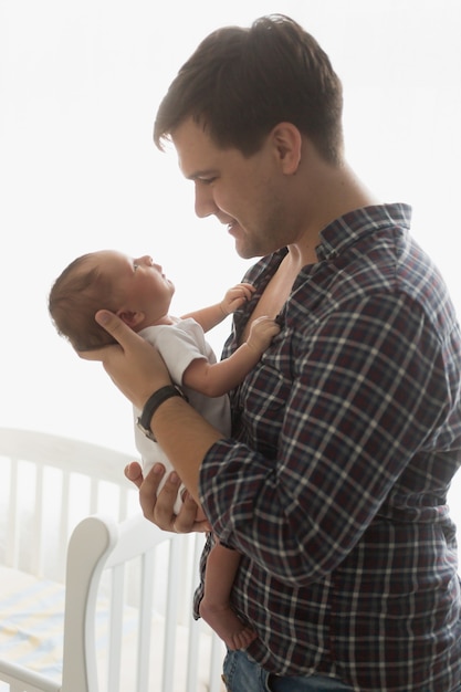 Retrato tonificado de pai feliz segurando um bebê recém-nascido