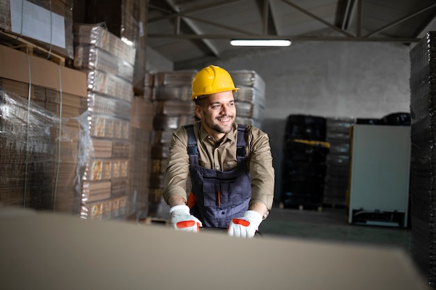 Retrato del trabajador de almacén sonriente caucásico que trabaja en la carretilla elevadora manual en la sala de almacenamiento.