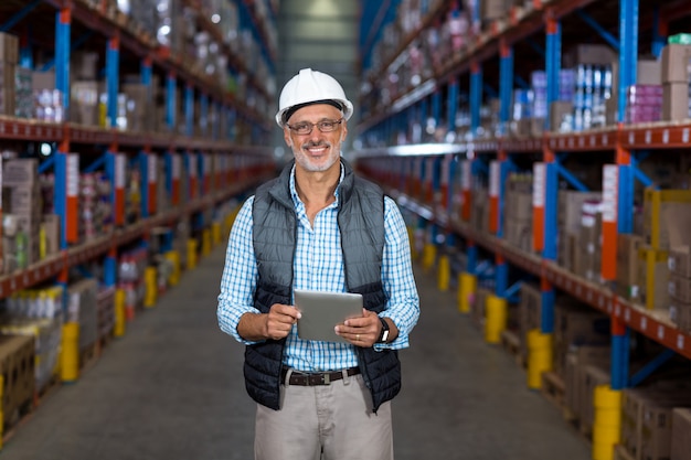 Retrato de trabajador feliz está sosteniendo una tableta y posando