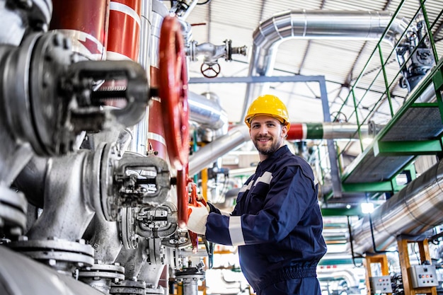 Retrato de un trabajador industrial en ropa de trabajo protectora en refinería o fábrica de petróleo