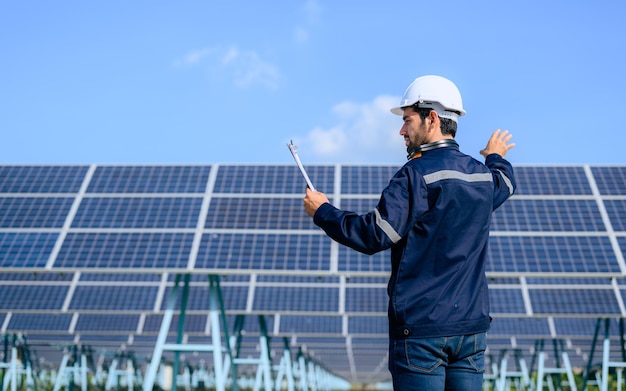 Retrato de trabajador ingeniero con panel solar en granja solar