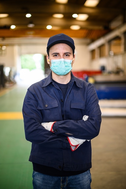 Retrato de un trabajador en una planta industrial con una máscara, concepto de coronavirus