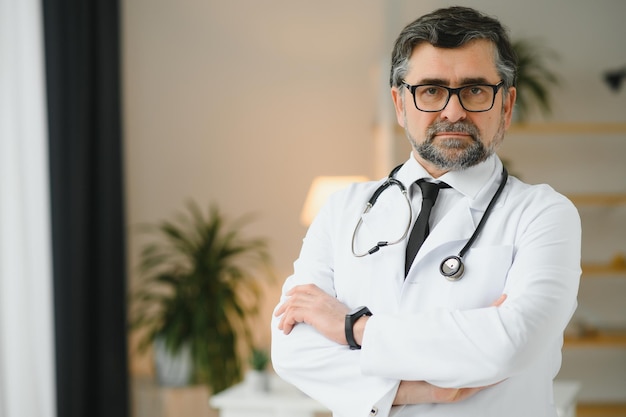 Retrato de un trabajador de la salud Imagen de un médico senior con bata de laboratorio y de pie en una clínica privada