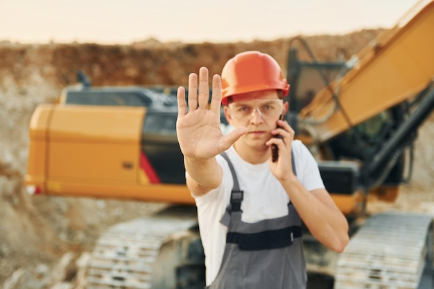 Retrato de trabajador con uniforme profesional que está en el pozo de préstamo durante el día