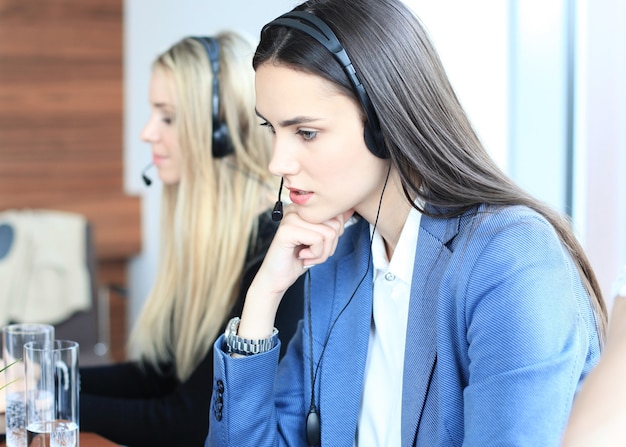 Retrato de trabajadora de call center acompañada de su equipo. Operador de soporte al cliente sonriente en el trabajo.