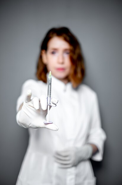 Retrato de una trabajadora médica con una jeringa en sus manos