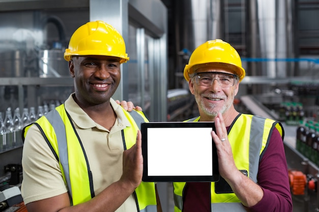 Retrato de trabajadores de fábrica con tableta digital en la planta