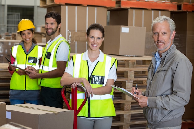 Foto retrato de trabajadores y gerente están sonriendo y posando cara a cámara